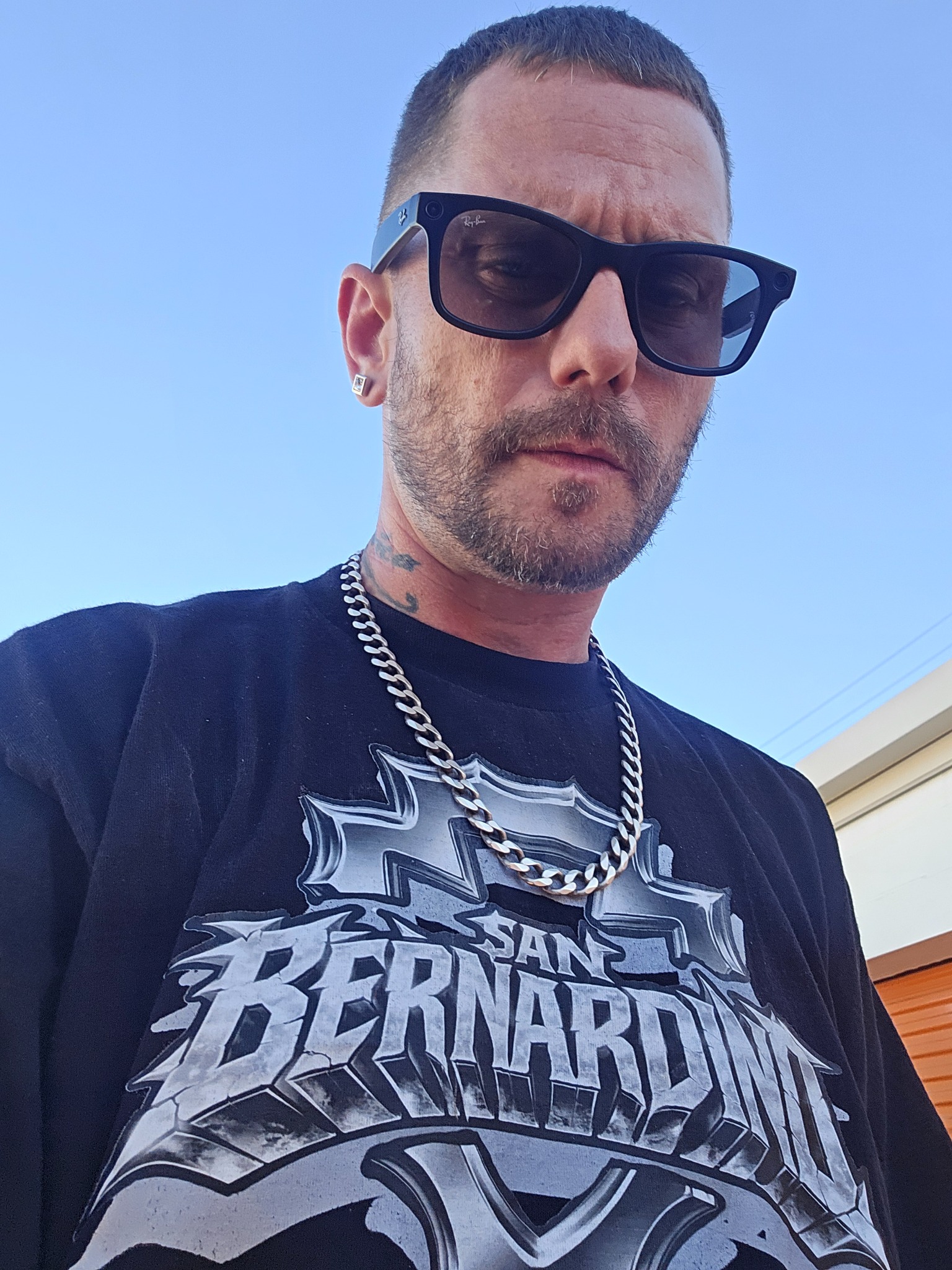 BarrKode wearing sunglasses, a silver chain, and a San Bernardino shirt.